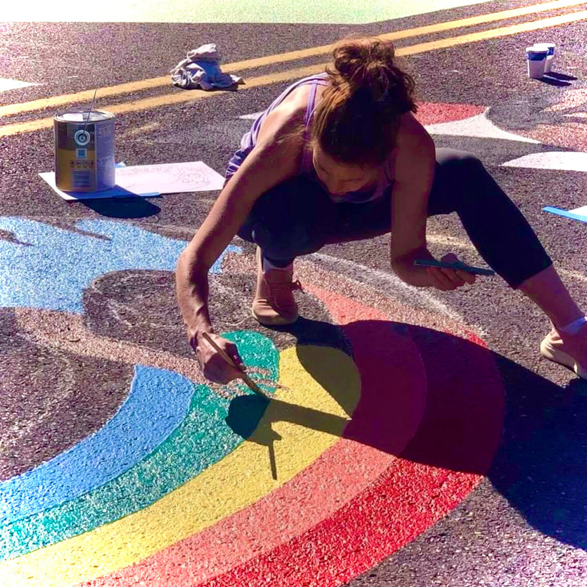 Brittany painting a street mural